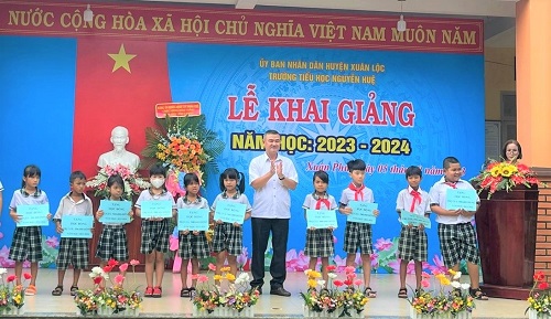 Đ.c Nguyễn Thanh Minh - PCT HND huyện Xuân Lộc trao tặng quà cho các em học sinh.jpg